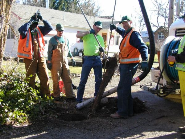 Crew removing roots in sewer line